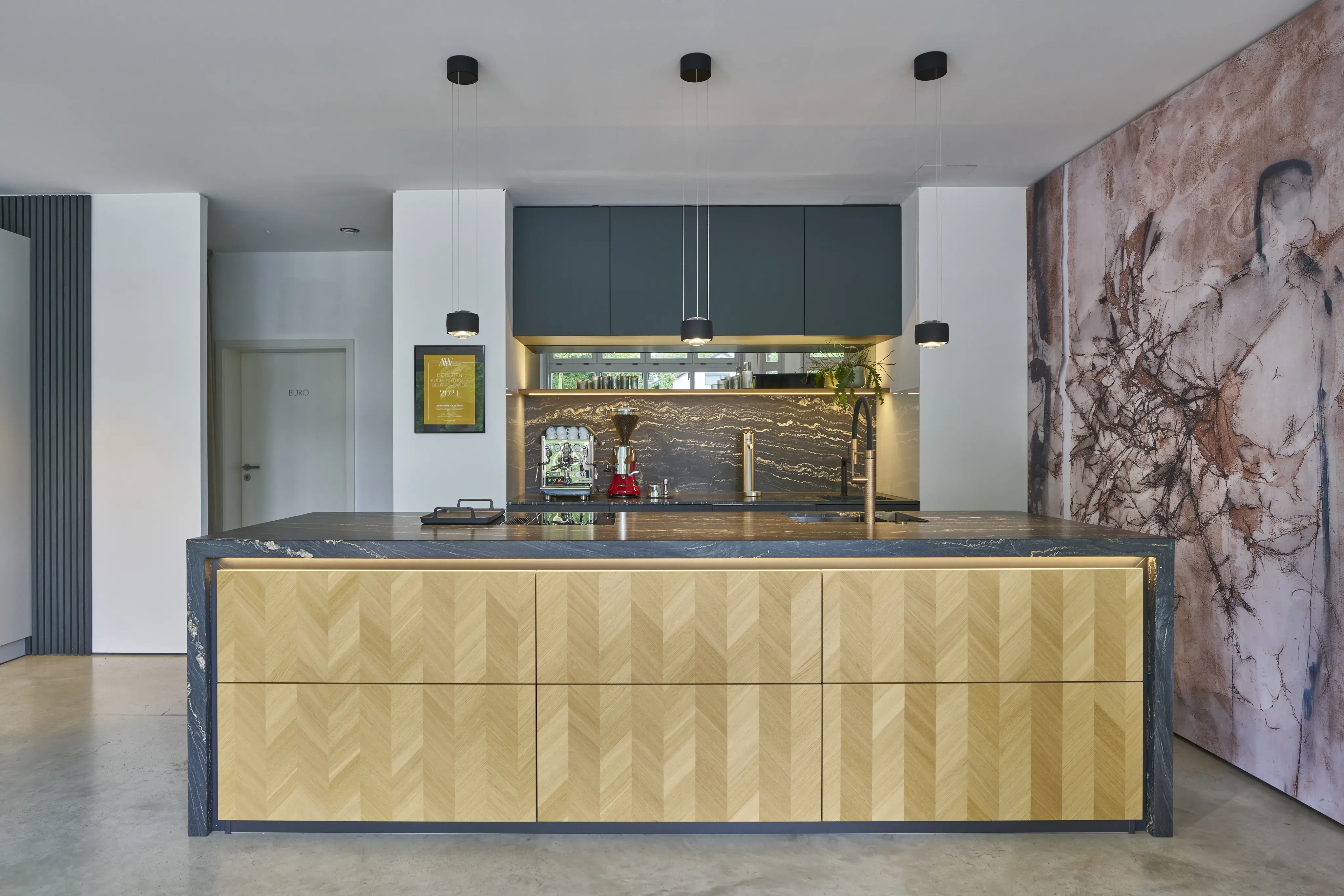 Moderne Küche mit gemustertem Holztresen, dunkler Arbeitsplatte und Marmorwand.