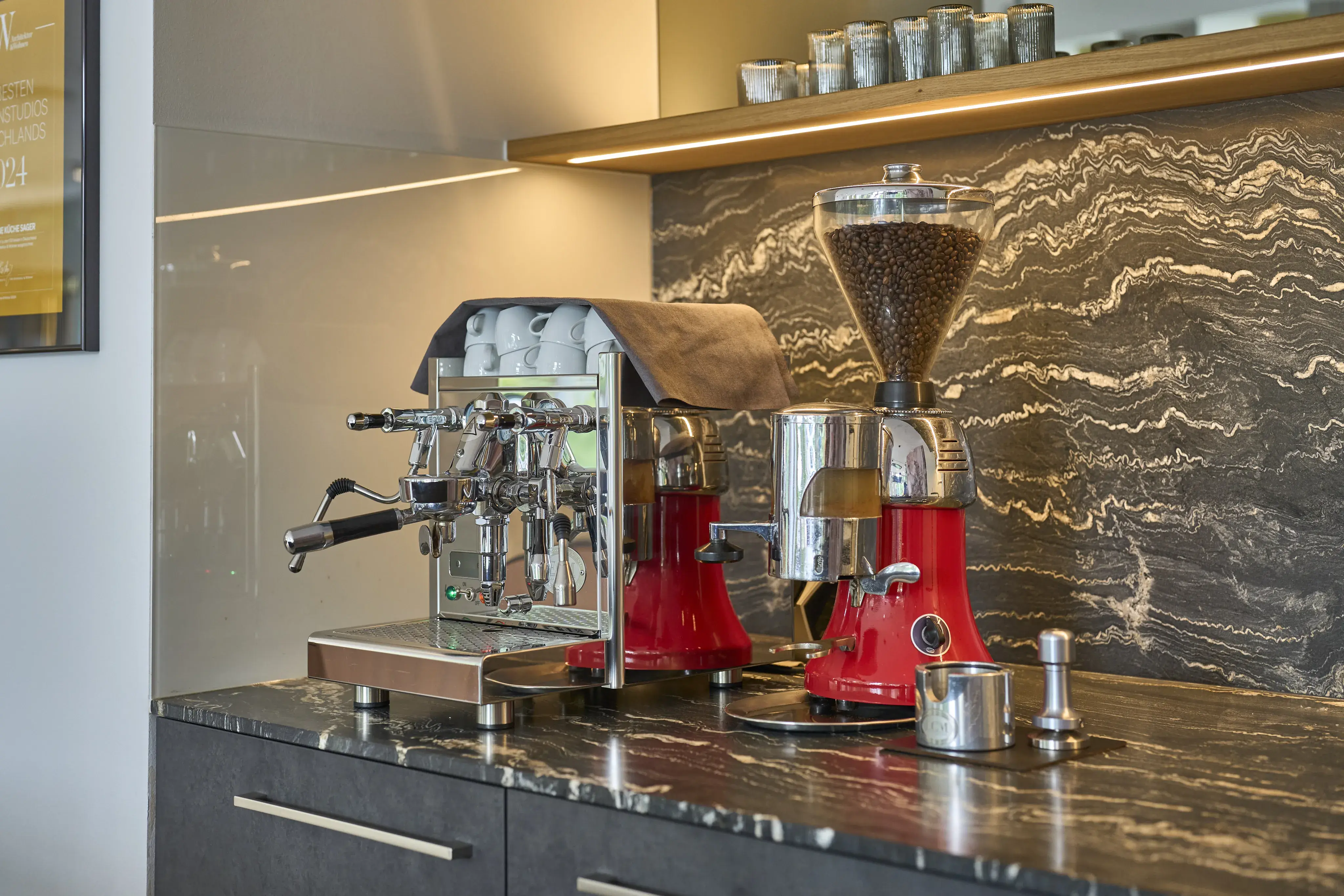 Espressomaschine und Kaffeemühle in einer modernen Küche auf dunkler Arbeitsplatte