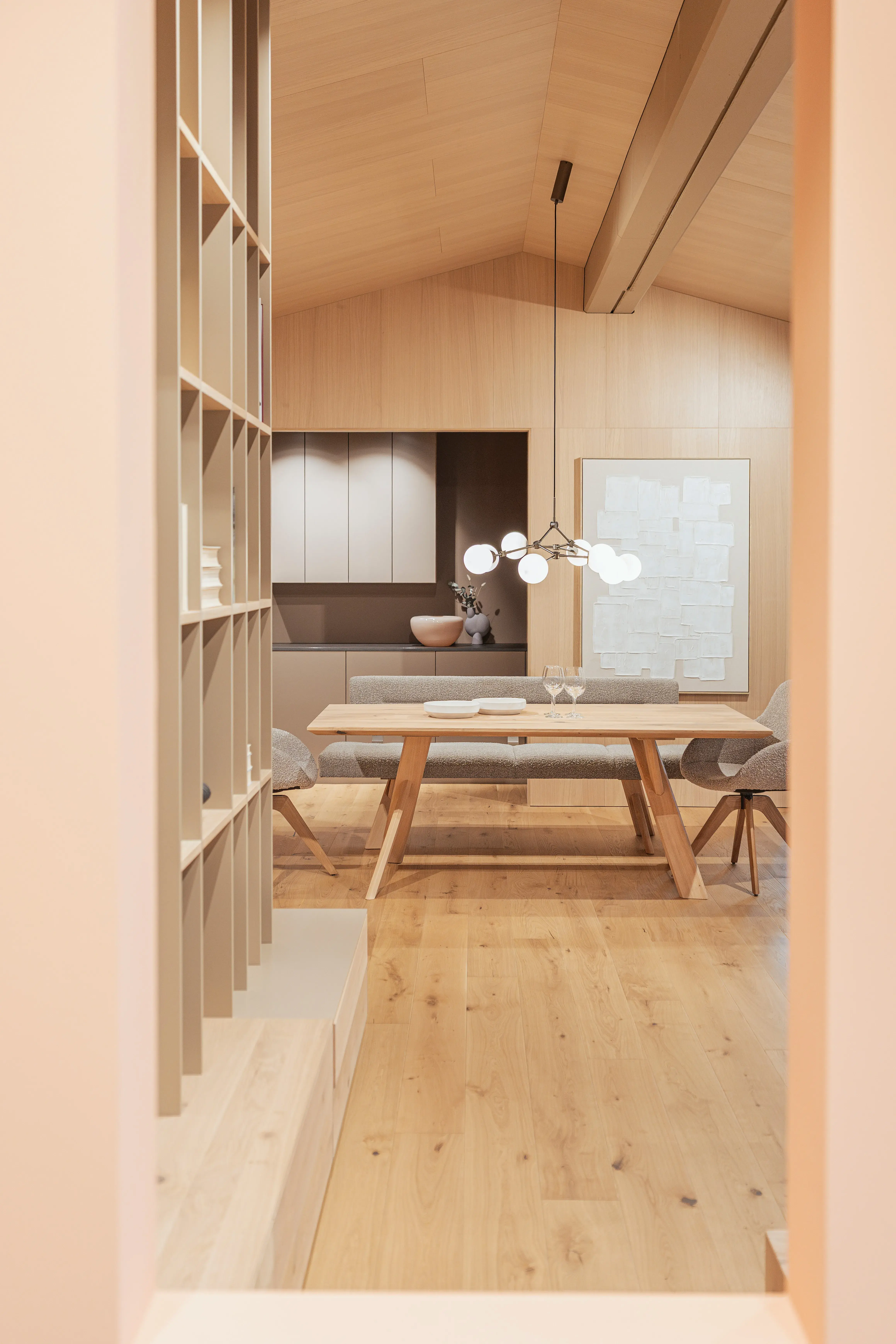 Helles Esszimmer mit Holztisch, Stühlen und modernem Kronleuchter.
