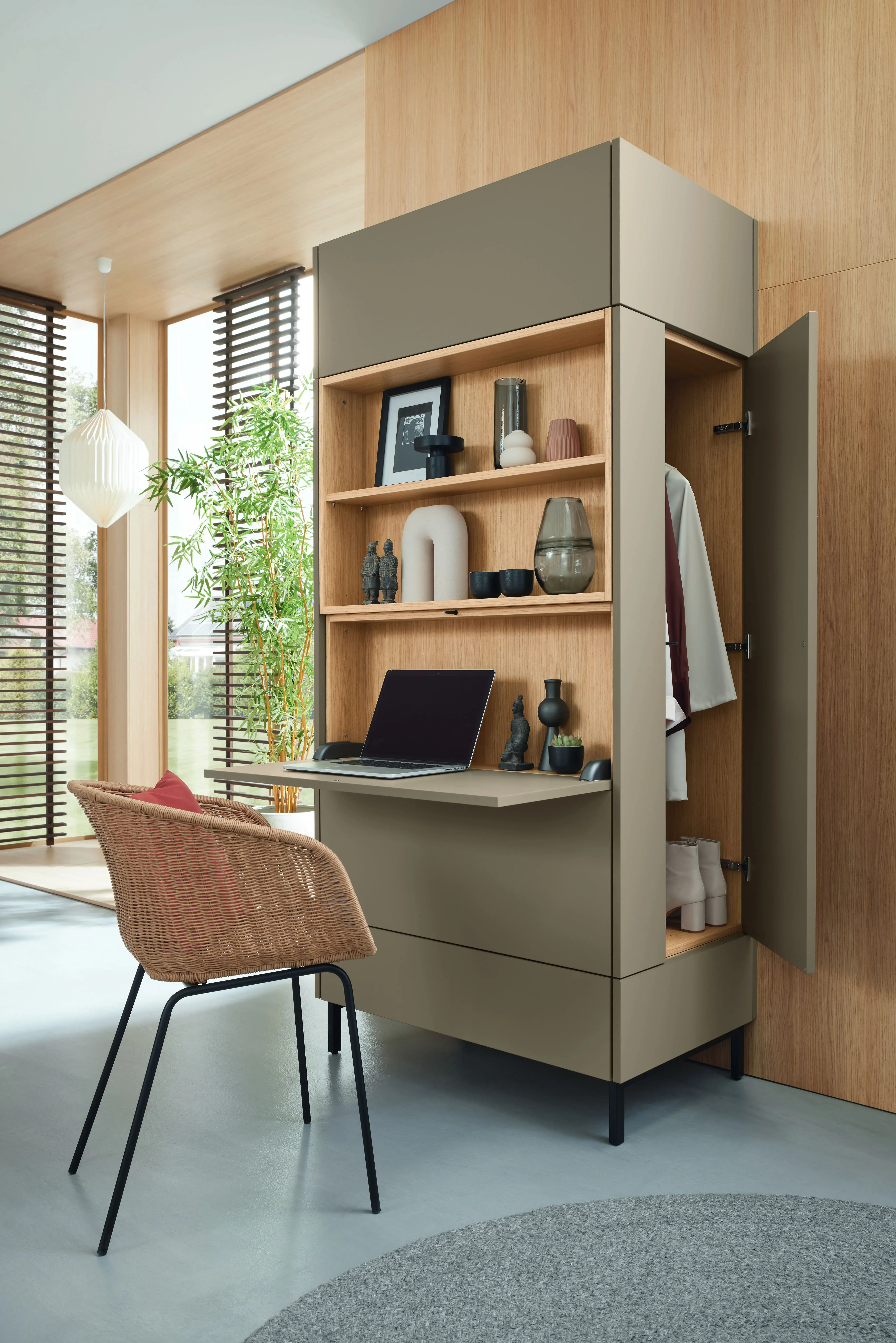 Modernes Homeoffice mit aufgeklapptem Schreibtisch, Laptop und Regalfächern in hellem Raum.