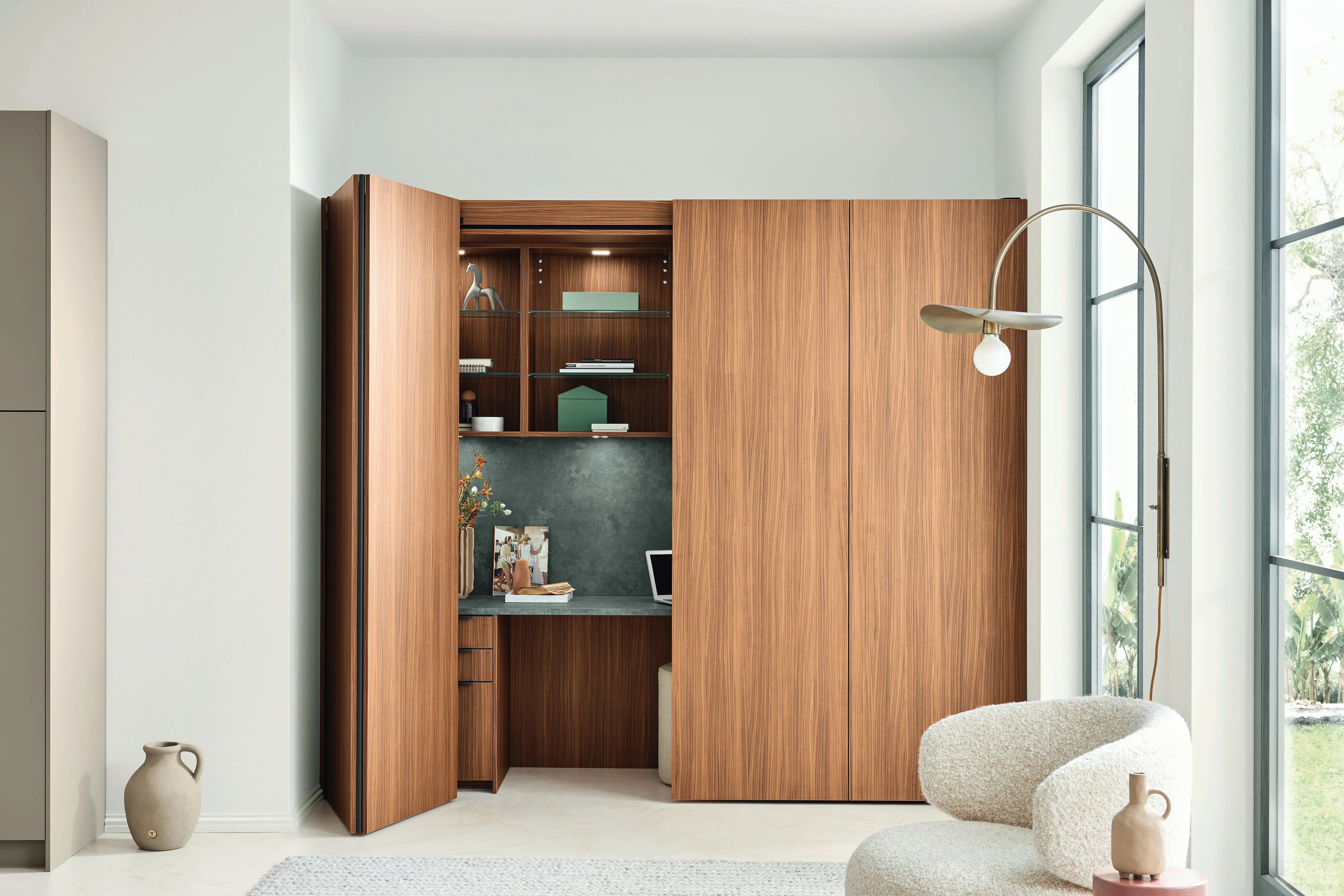 Offener Einbauschrank aus Holz mit kleinem Arbeitsplatz und Regalen in modernem Wohnzimmer.